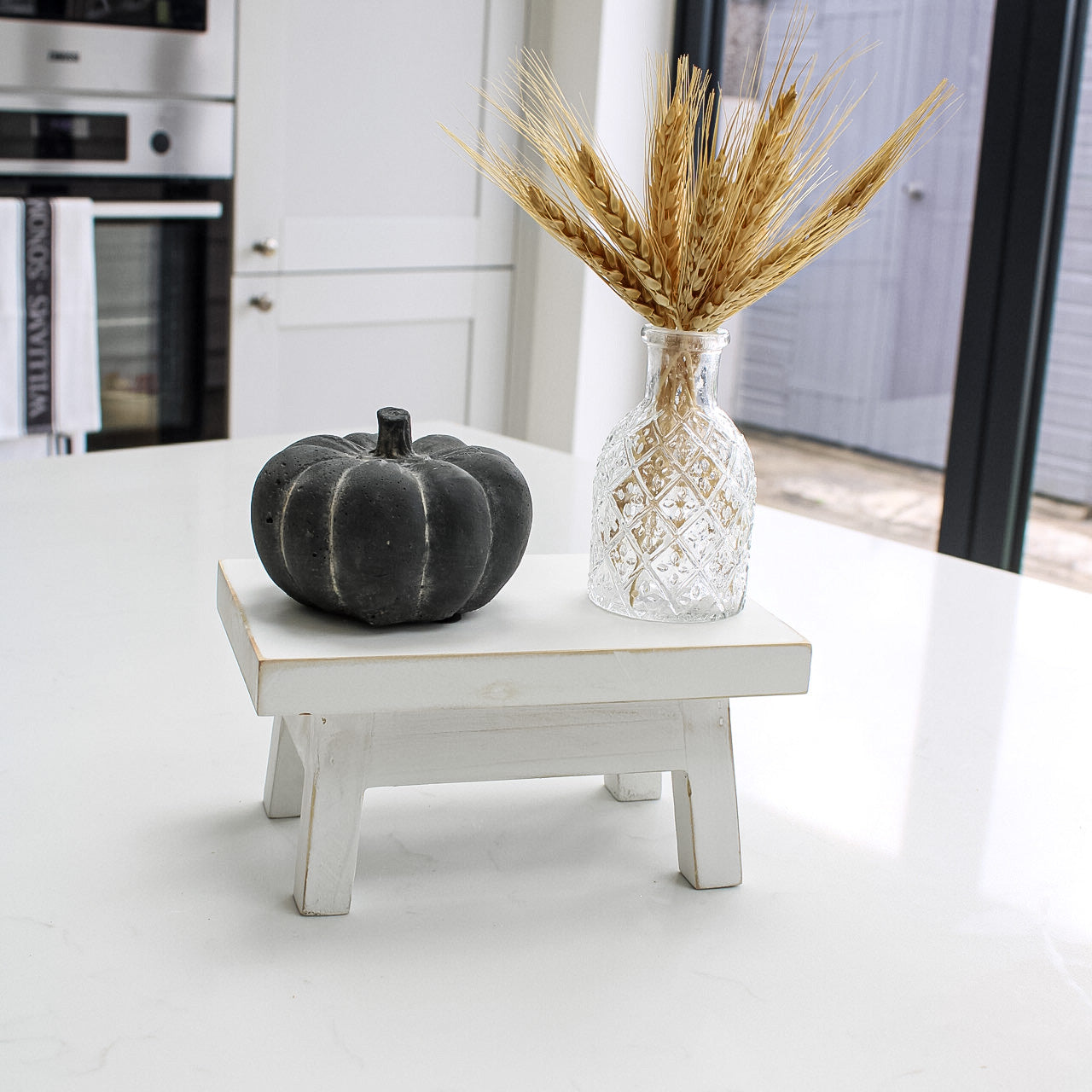 small bench with pumpkin and bud glass vase for home decoration