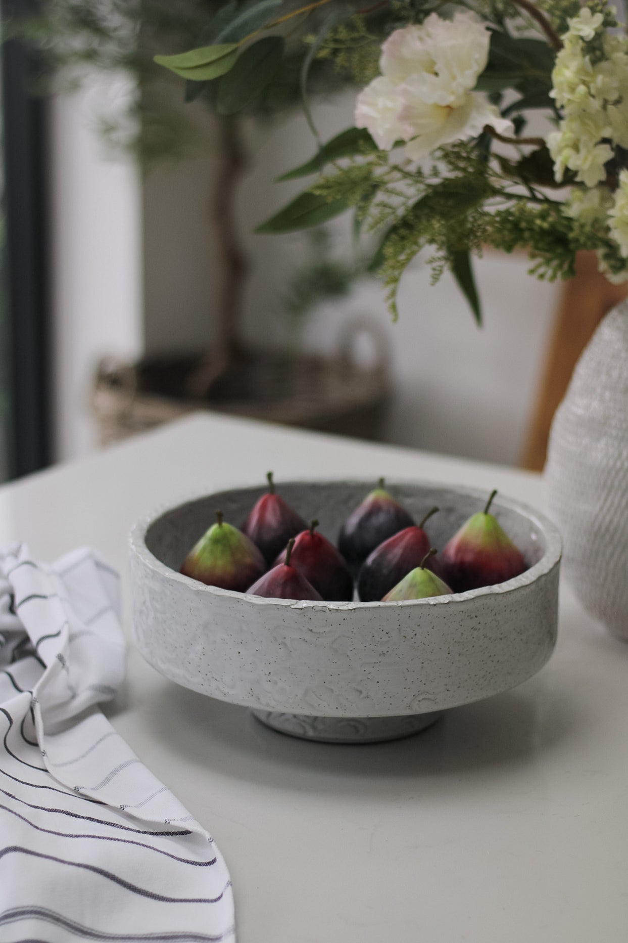 grey pedestal bowl filled with faux figs