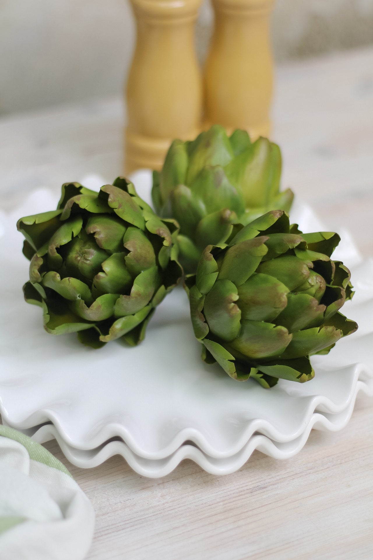 faux green artichoke on ruffled ceramic plate