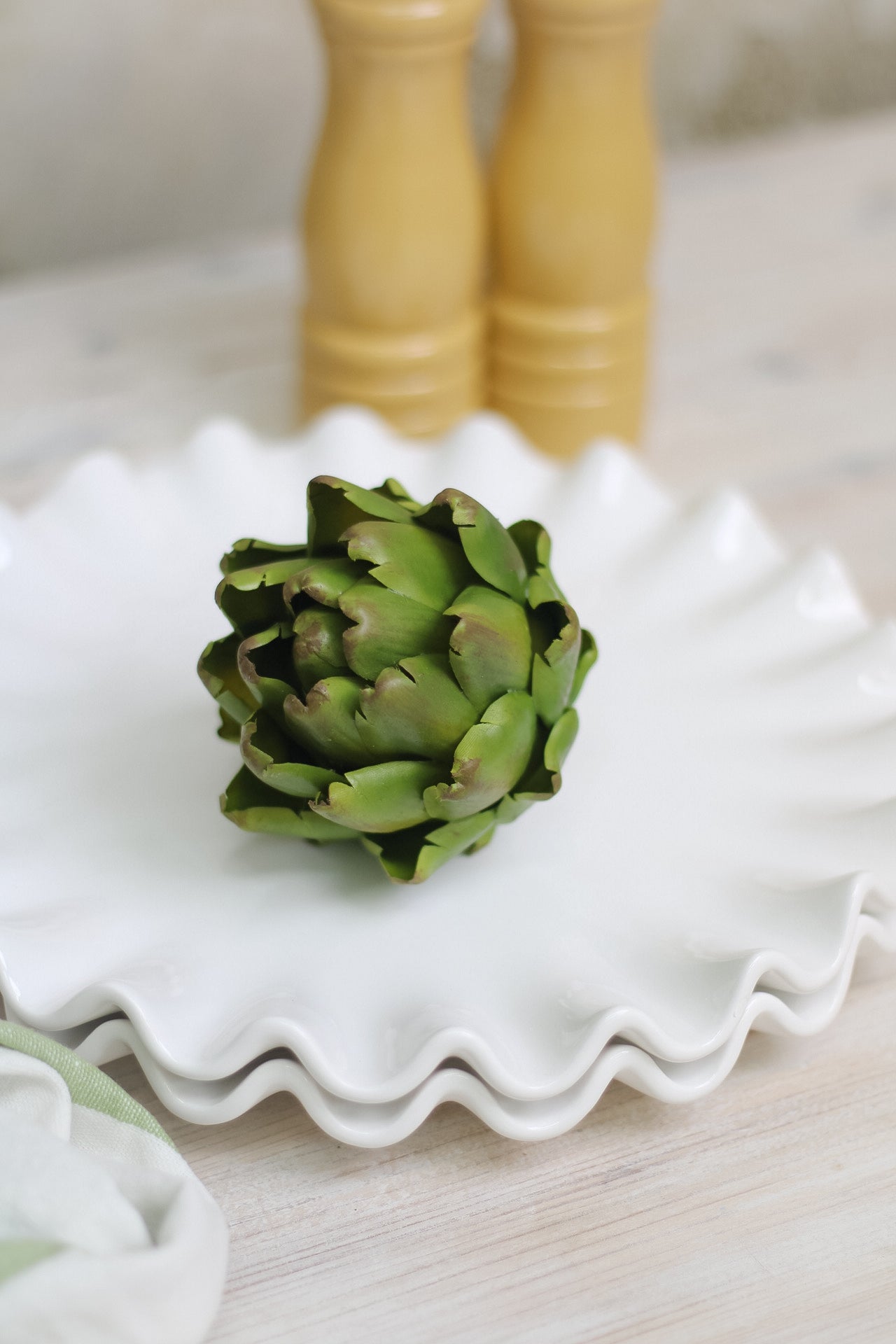 single decorative faux artichoke on ruffled plate