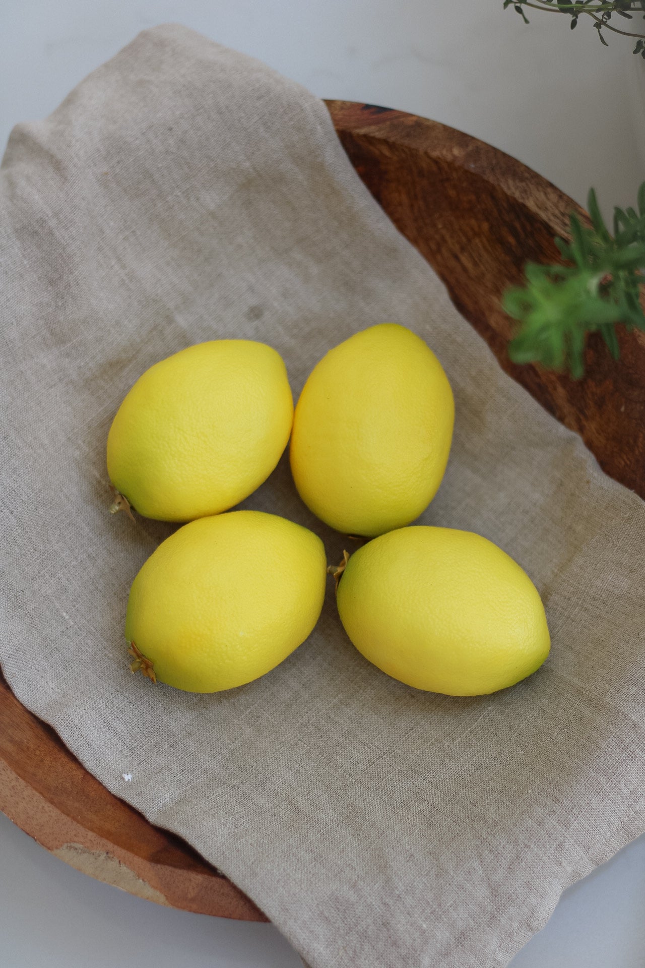 close up Decorative Faux Lemons in wooden bowl