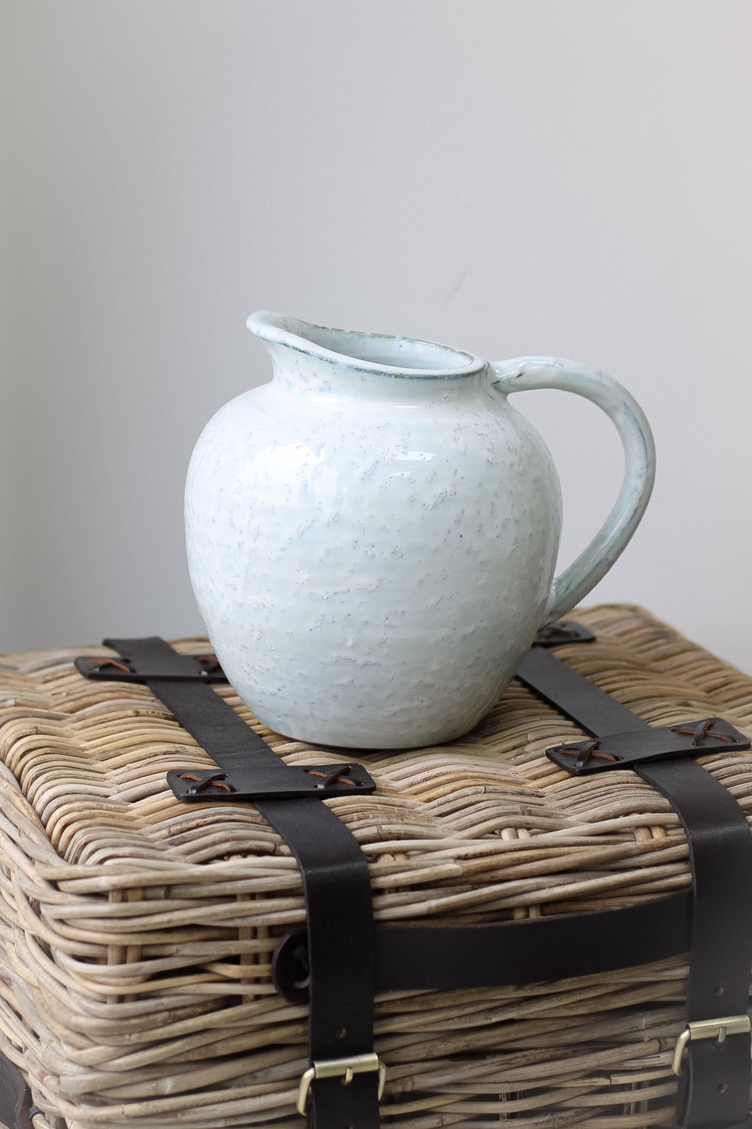 Rustic jug on wicker end table. Introduce modern rustic charm to your home decor.