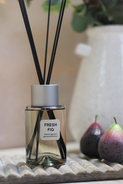 Fresh Fig Reed Diffuser on top of vintage wooden wash board next to a pair of faux figs