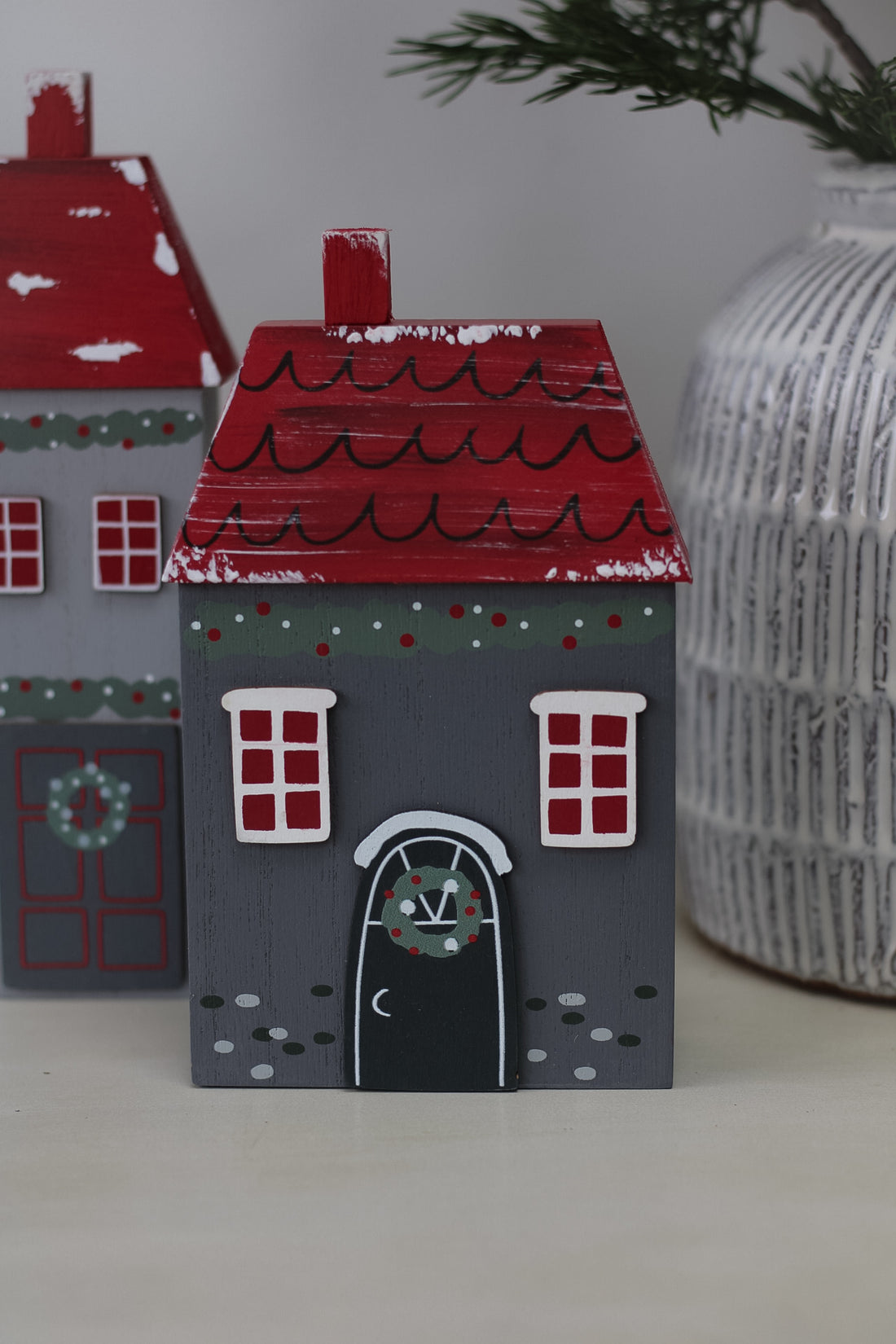 up close of small charcoal grey christmas house with wreath on front door