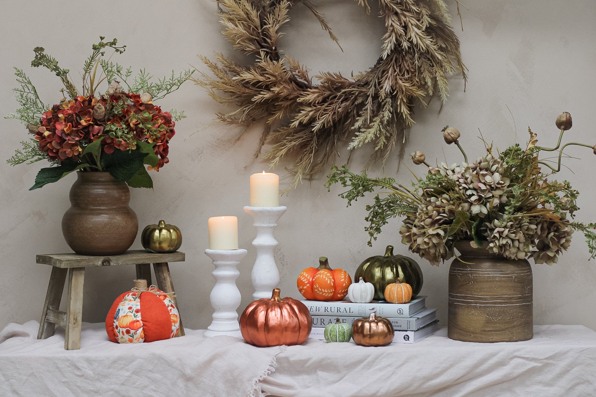 collection of pumpkins and faux flowers in vase for home decor