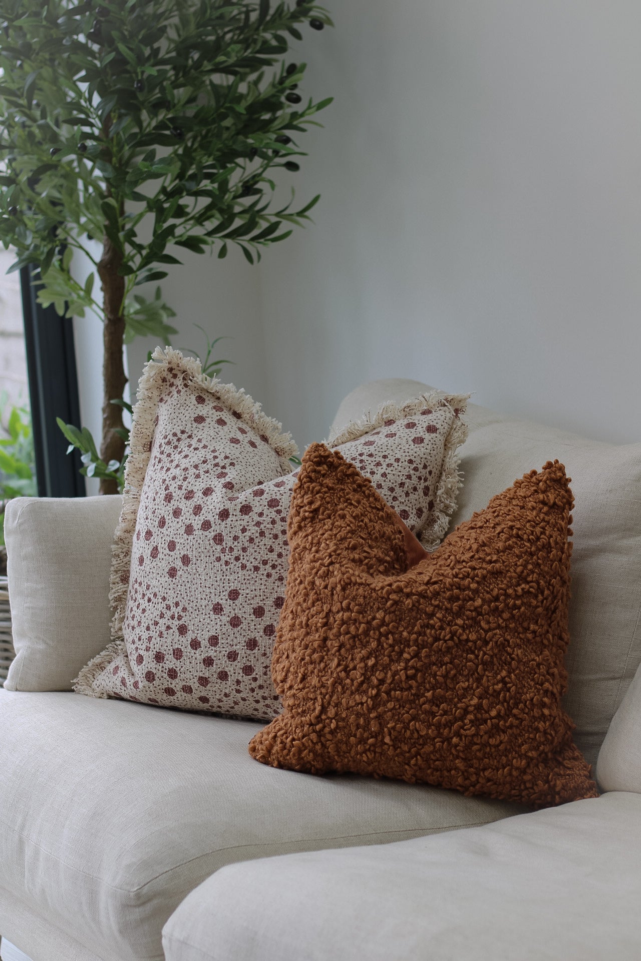 sofa with ginger boucle cushion and dotty fringed cushion for home decor