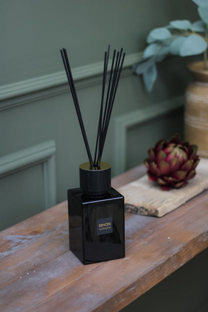 Onyx Sences Alang Alang Reed Diffuser sat on rustic wooden side table