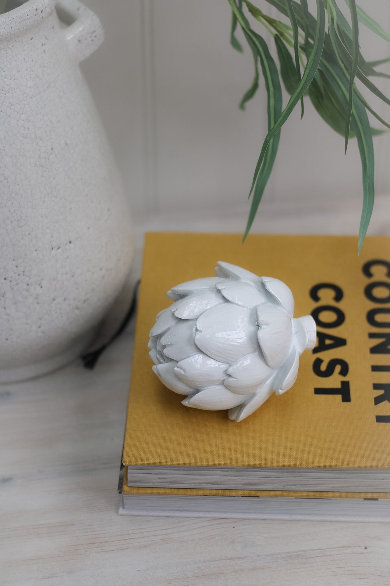 White Artichoke Decoration on top of coffee table book