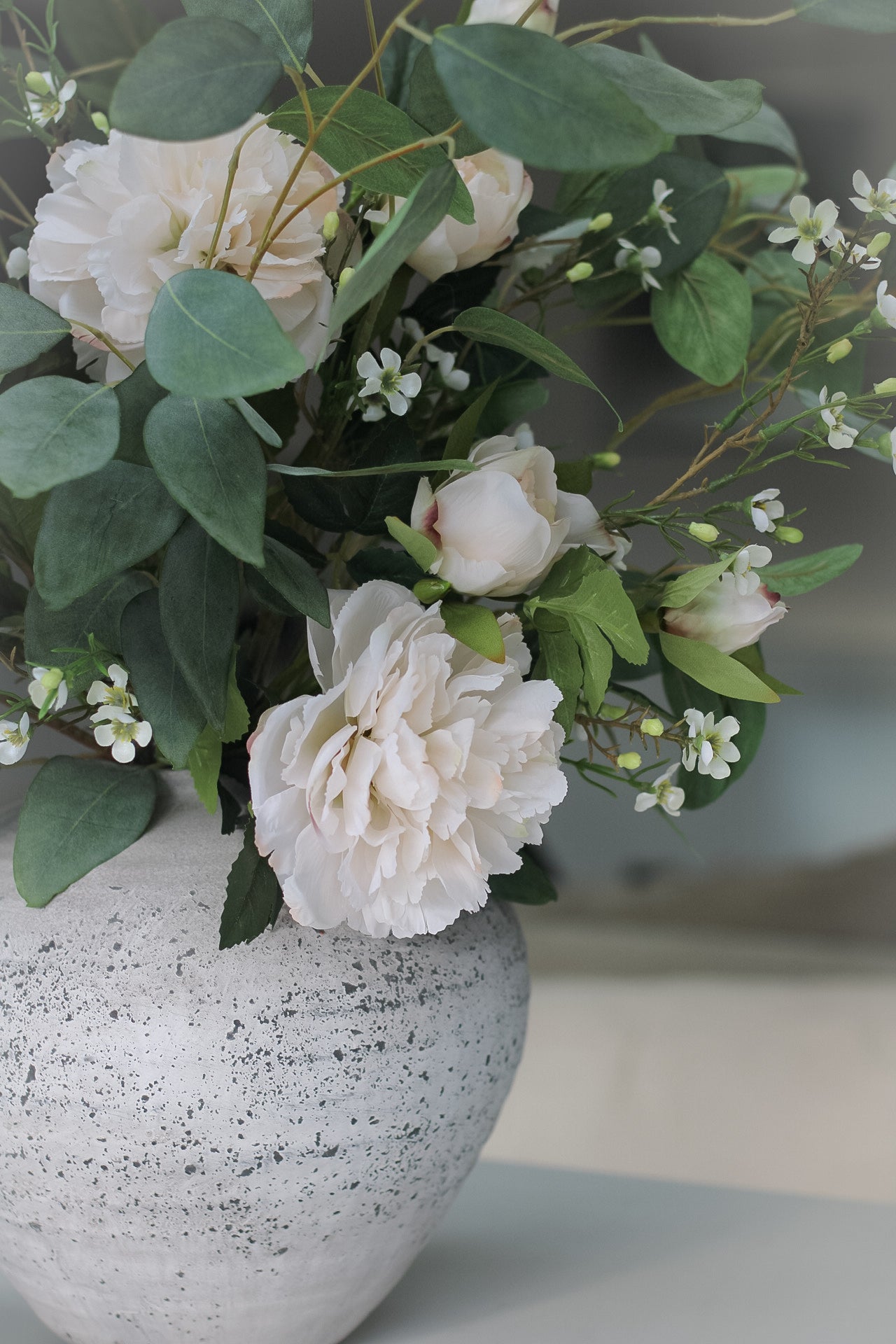 faux flowers in rustic stone vase