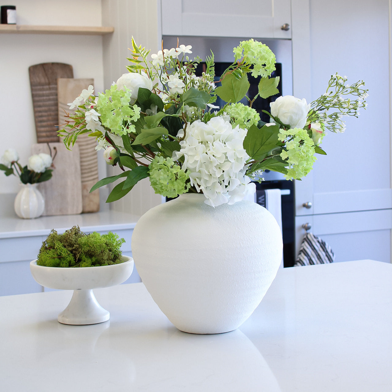 white ceramic vase filled with faux flowers